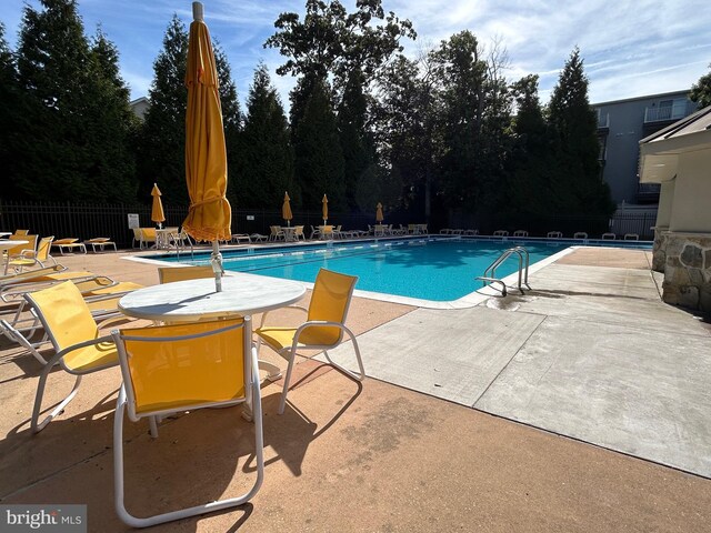 pool featuring a patio area and fence