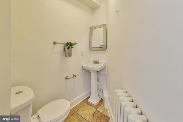 bathroom with radiator heating unit and toilet