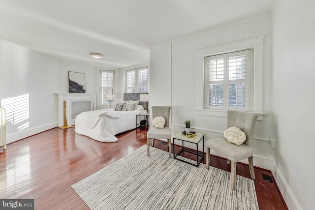 bedroom with hardwood / wood-style floors and a fireplace