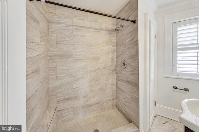 bathroom featuring crown molding, vanity, and a tile shower