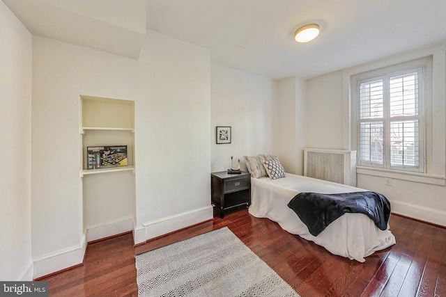 bedroom with dark hardwood / wood-style flooring