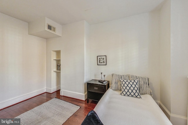 bedroom with dark hardwood / wood-style flooring