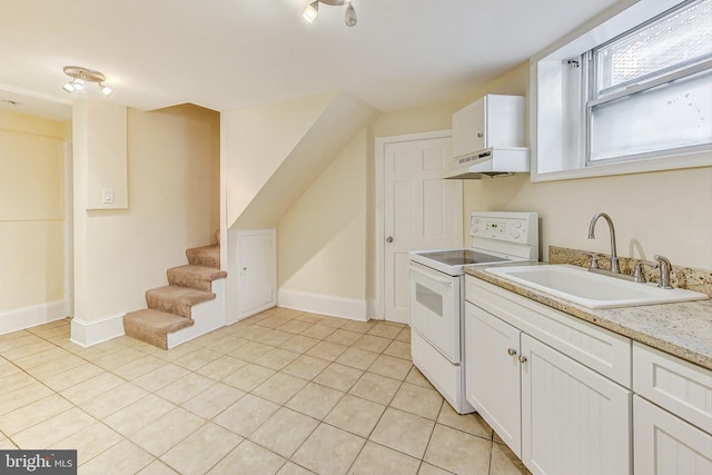 kitchen featuring light tile patterned floors, white range with electric stovetop, white cabinetry, and sink