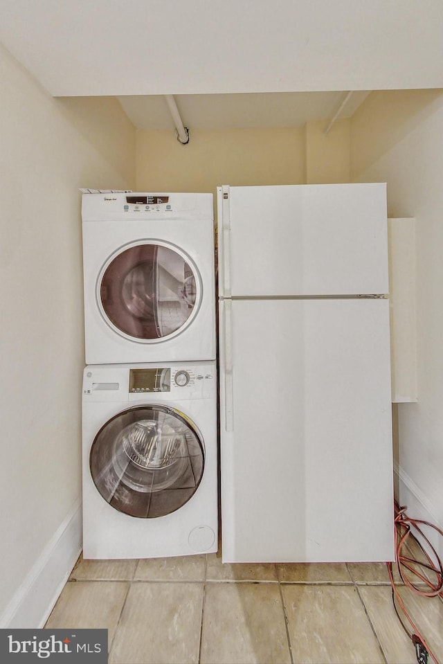 clothes washing area featuring stacked washer and dryer