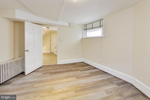 empty room featuring light wood-type flooring and radiator