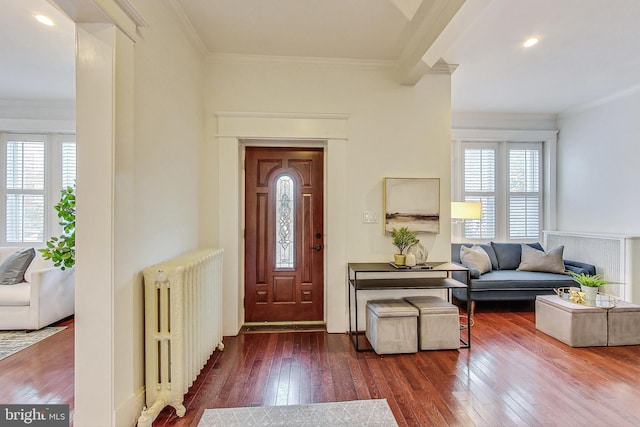 entryway with ornamental molding, radiator, and dark hardwood / wood-style flooring