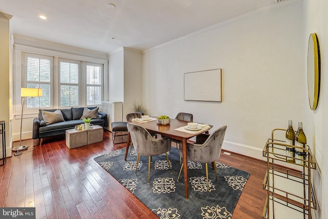 dining room with ornamental molding and dark hardwood / wood-style floors