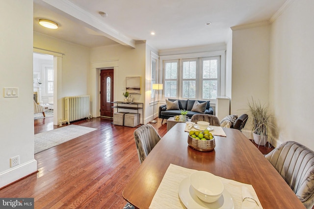 dining room with radiator heating unit, crown molding, and dark hardwood / wood-style floors