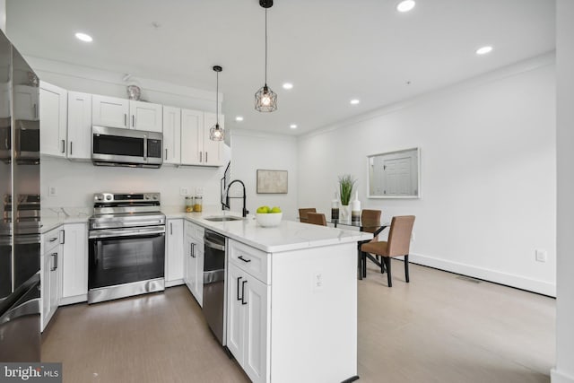 kitchen with stainless steel appliances, white cabinets, hanging light fixtures, and sink