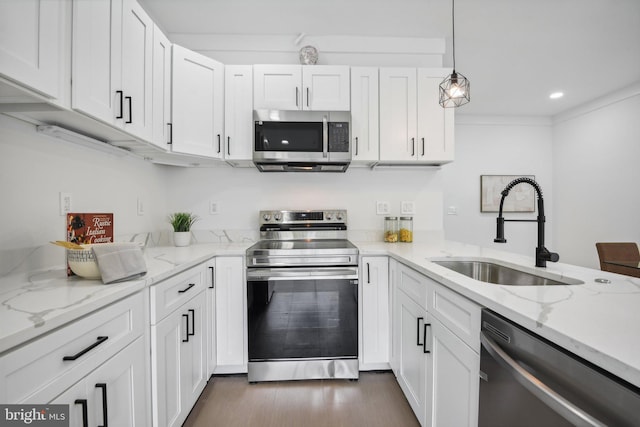 kitchen featuring pendant lighting, stainless steel appliances, white cabinets, and sink