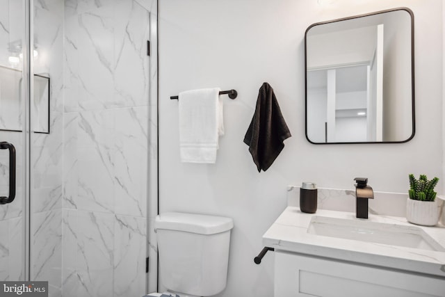 bathroom featuring vanity, an enclosed shower, and toilet