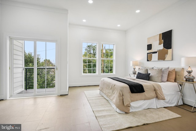 bedroom featuring ornamental molding, light hardwood / wood-style floors, and multiple windows