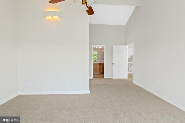 unfurnished room featuring light colored carpet, high vaulted ceiling, and ceiling fan