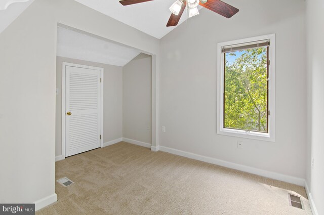 interior space featuring lofted ceiling, ceiling fan, and light colored carpet