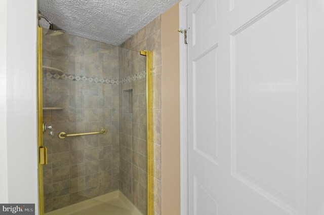 bathroom featuring walk in shower and a textured ceiling