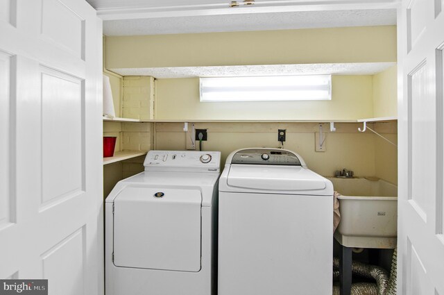 laundry room with plenty of natural light, washer and clothes dryer, and sink