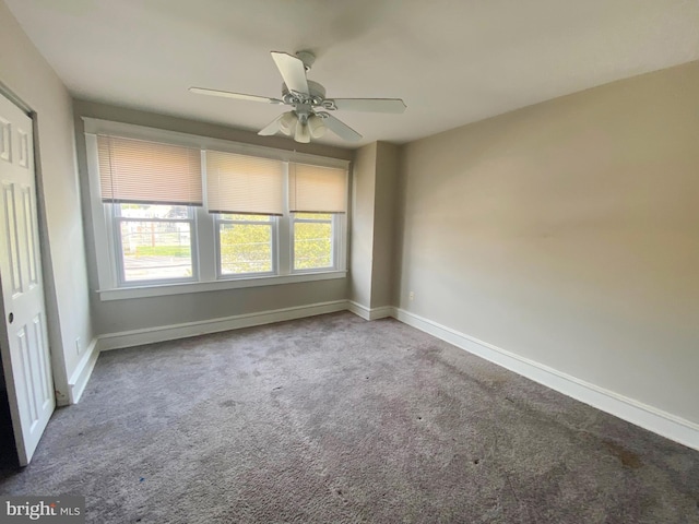 carpeted spare room with ceiling fan