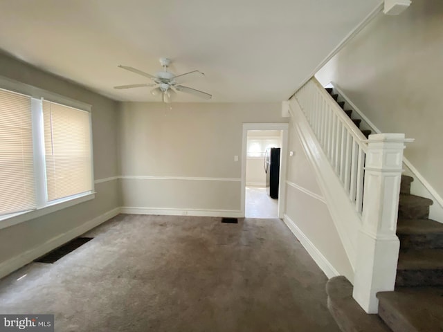 carpeted spare room with ceiling fan