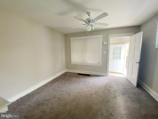 unfurnished bedroom featuring dark colored carpet and ceiling fan