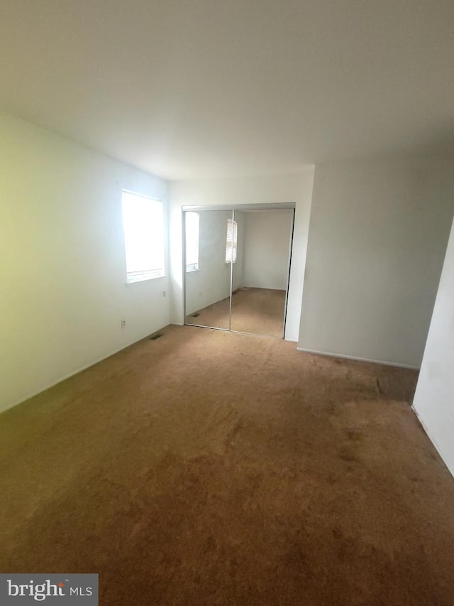 unfurnished bedroom featuring carpet floors and a closet