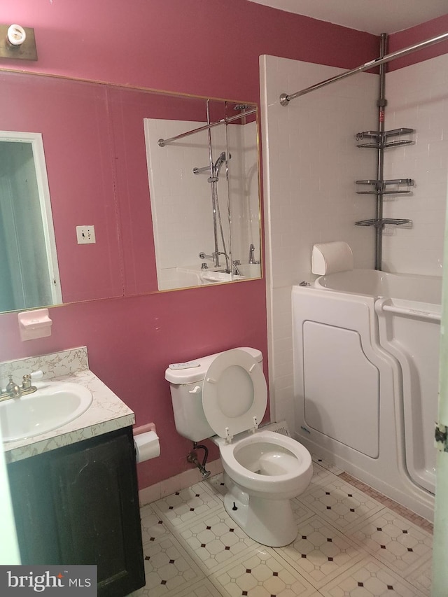 bathroom featuring washer / dryer, vanity, and toilet