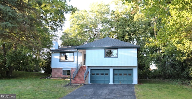 view of front facade with stairway, driveway, a chimney, and a front lawn