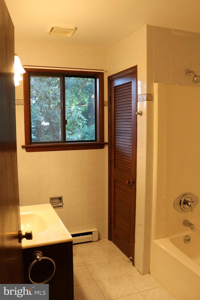 bathroom with tile patterned floors, vanity, shower / bathtub combination, a baseboard heating unit, and tile walls