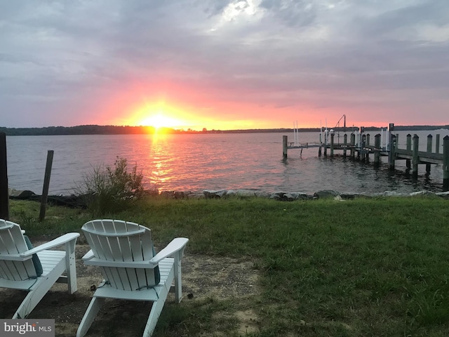 dock area featuring boat lift and a water view