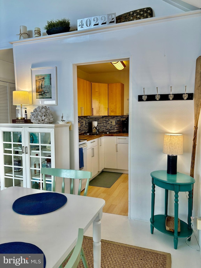 kitchen featuring white range with electric stovetop, tasteful backsplash, and light hardwood / wood-style flooring