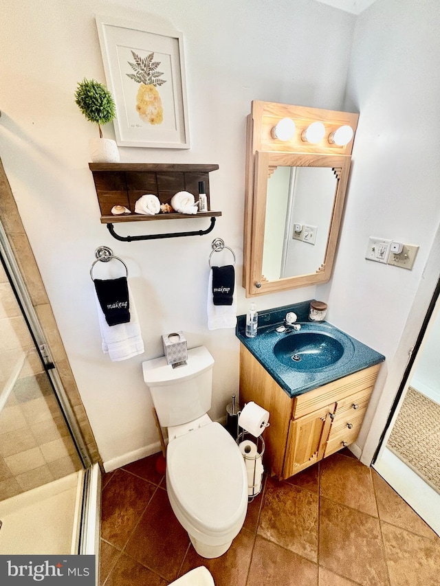 bathroom featuring vanity, toilet, walk in shower, and tile patterned flooring