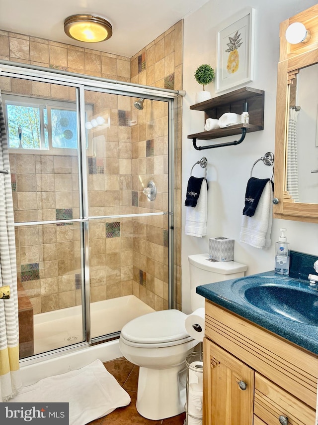 full bathroom featuring vanity, toilet, and a shower stall