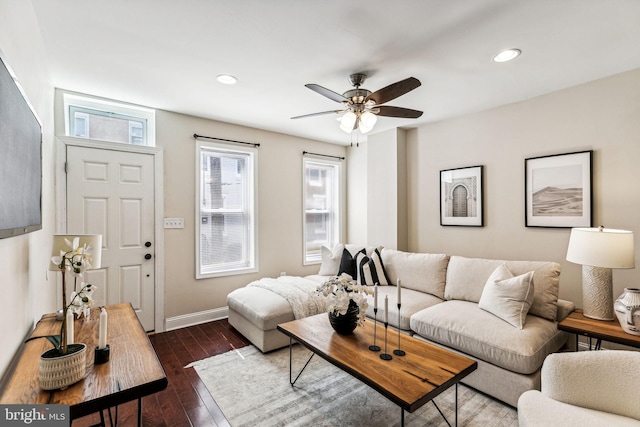 living room featuring dark wood-type flooring and ceiling fan