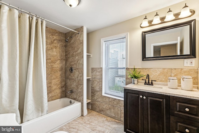 bathroom featuring shower / bath combo with shower curtain, tile walls, a wealth of natural light, and vanity