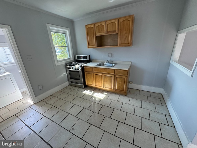 kitchen with stainless steel gas stove, ornamental molding, sink, washer / dryer, and light tile patterned flooring