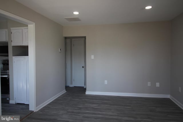 empty room with recessed lighting, baseboards, and dark wood-style flooring