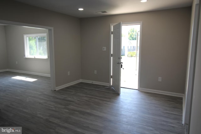 unfurnished room featuring a wealth of natural light, baseboards, and dark wood-style floors