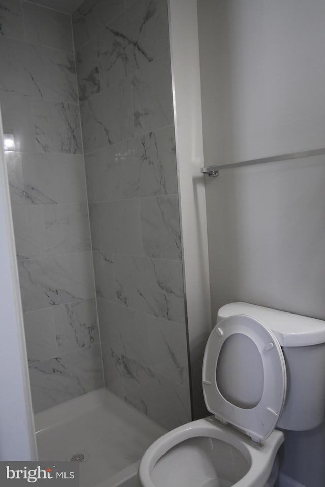 bathroom featuring a shower stall and toilet