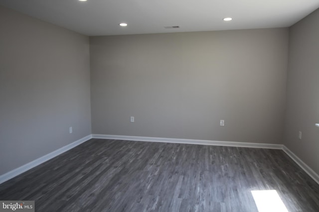 empty room with visible vents, recessed lighting, dark wood-style floors, and baseboards