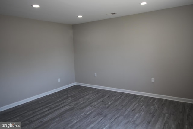 spare room with recessed lighting, baseboards, and dark wood-style flooring