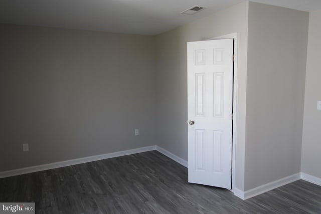 unfurnished bedroom with visible vents, dark wood-style floors, and baseboards