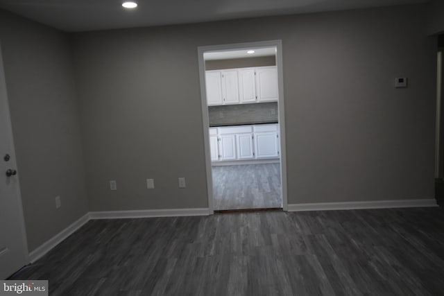 unfurnished room featuring dark wood-style floors, recessed lighting, and baseboards