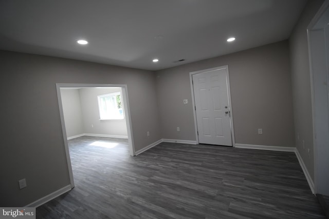 empty room featuring recessed lighting, baseboards, and dark wood finished floors