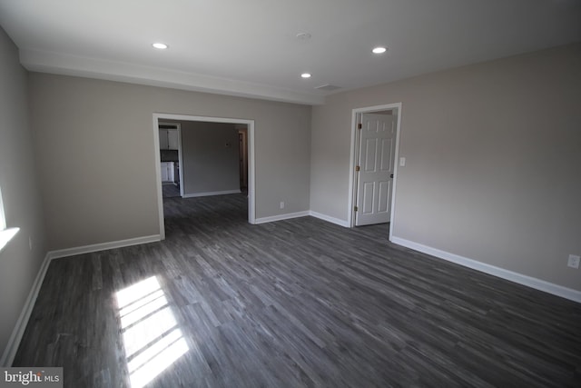 empty room with dark wood-type flooring, recessed lighting, and baseboards