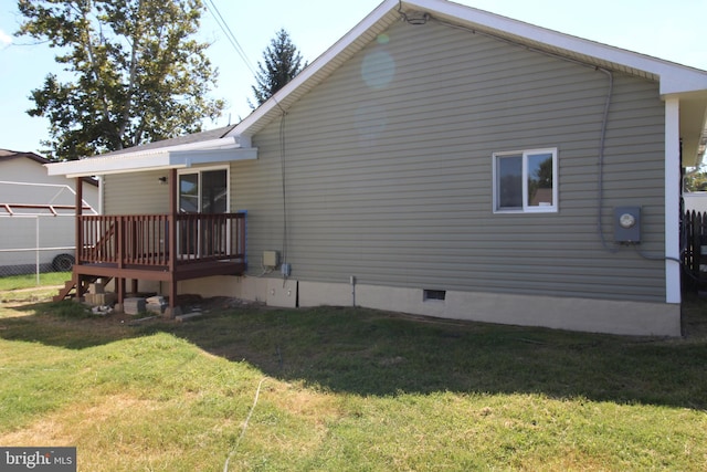 rear view of house with crawl space, a wooden deck, a yard, and fence