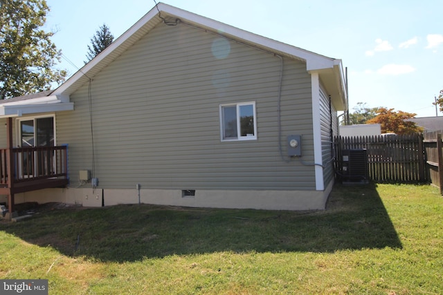 view of property exterior with crawl space, central air condition unit, a yard, and fence