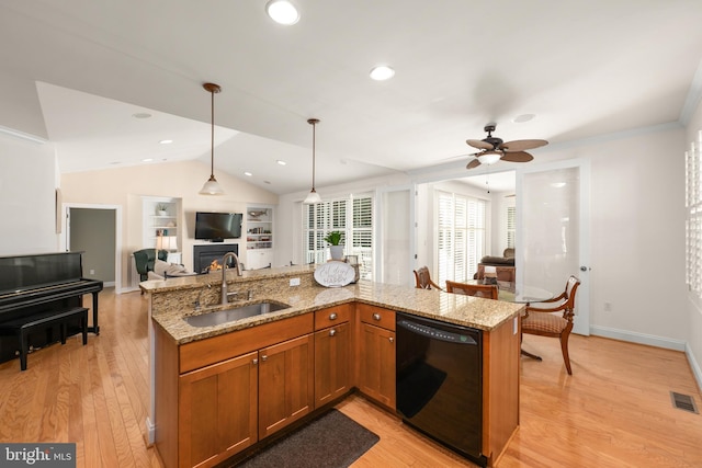 kitchen featuring hanging light fixtures, dishwasher, sink, and light hardwood / wood-style flooring