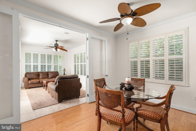 dining area with ornamental molding, light hardwood / wood-style floors, and a wealth of natural light