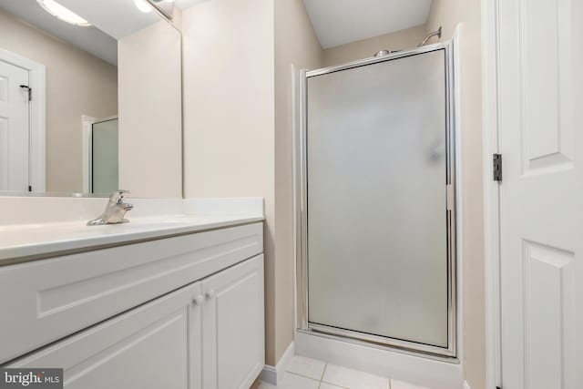 bathroom featuring tile patterned flooring, vanity, and walk in shower