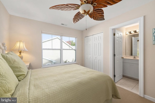 bedroom featuring ensuite bath, a closet, ceiling fan, and light tile patterned flooring