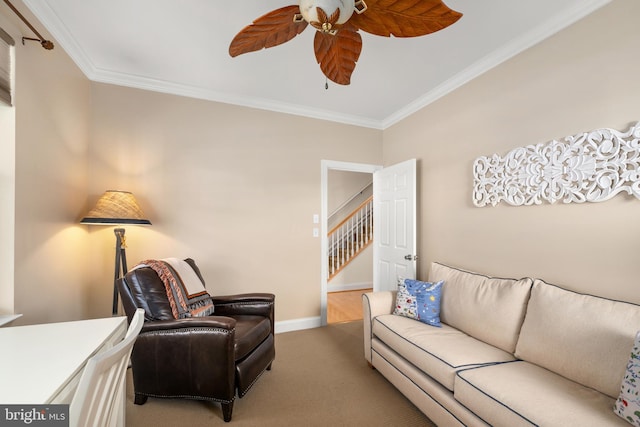 carpeted living room with crown molding and ceiling fan